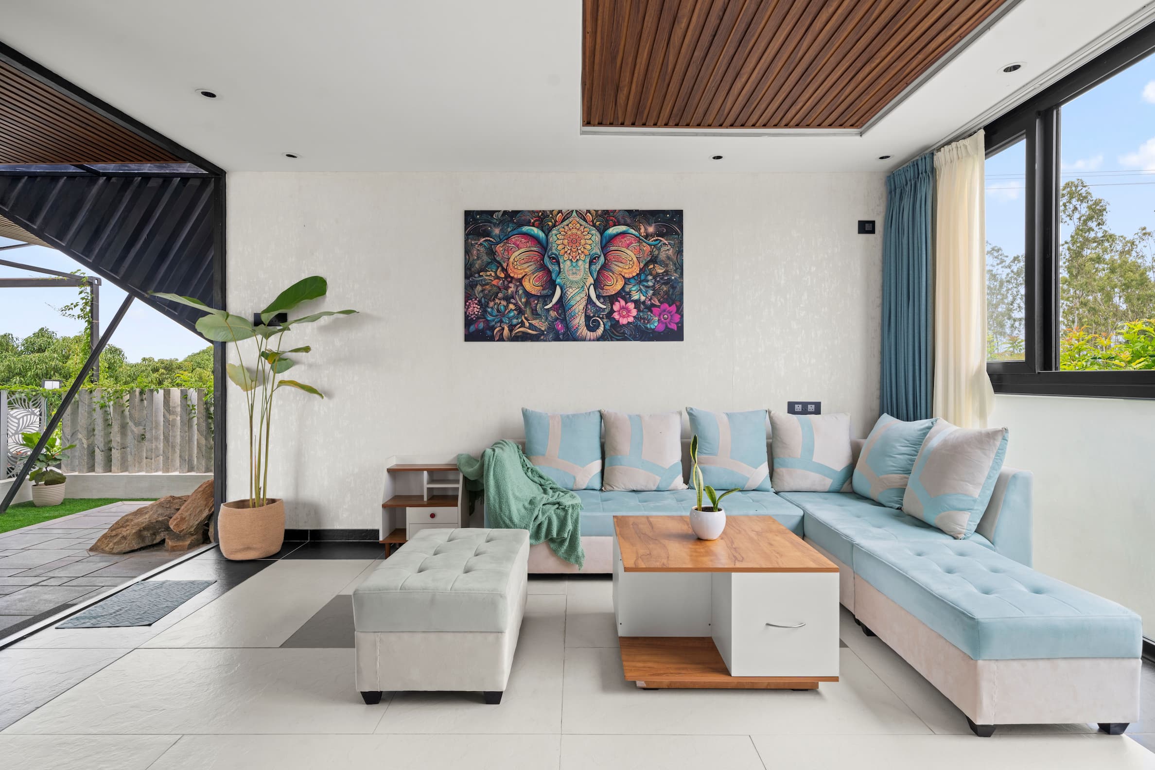 Qbinn Tusker living room with elephant painting and teal sofas